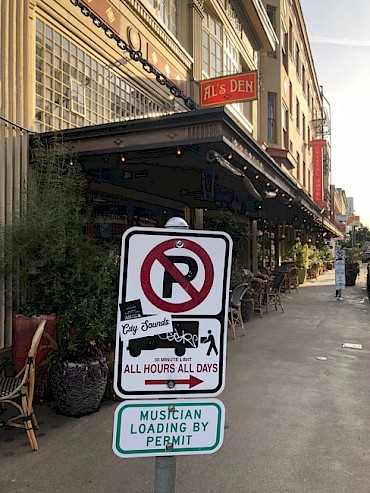A new Musician Loading By Permit sign outside Al's Den in SW Portland. Celebrate the pilot program's launch outside Dante’s (in a loading zone) at 1:15pm on March 15 with a performance from And And And!